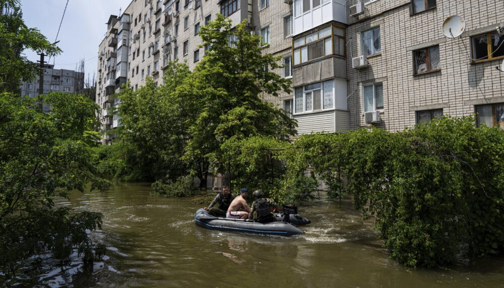 Ukrainian servicemen evacuate a man by a boat from a flooded neighborhood in Kherson, Ukraine, in June 2023.